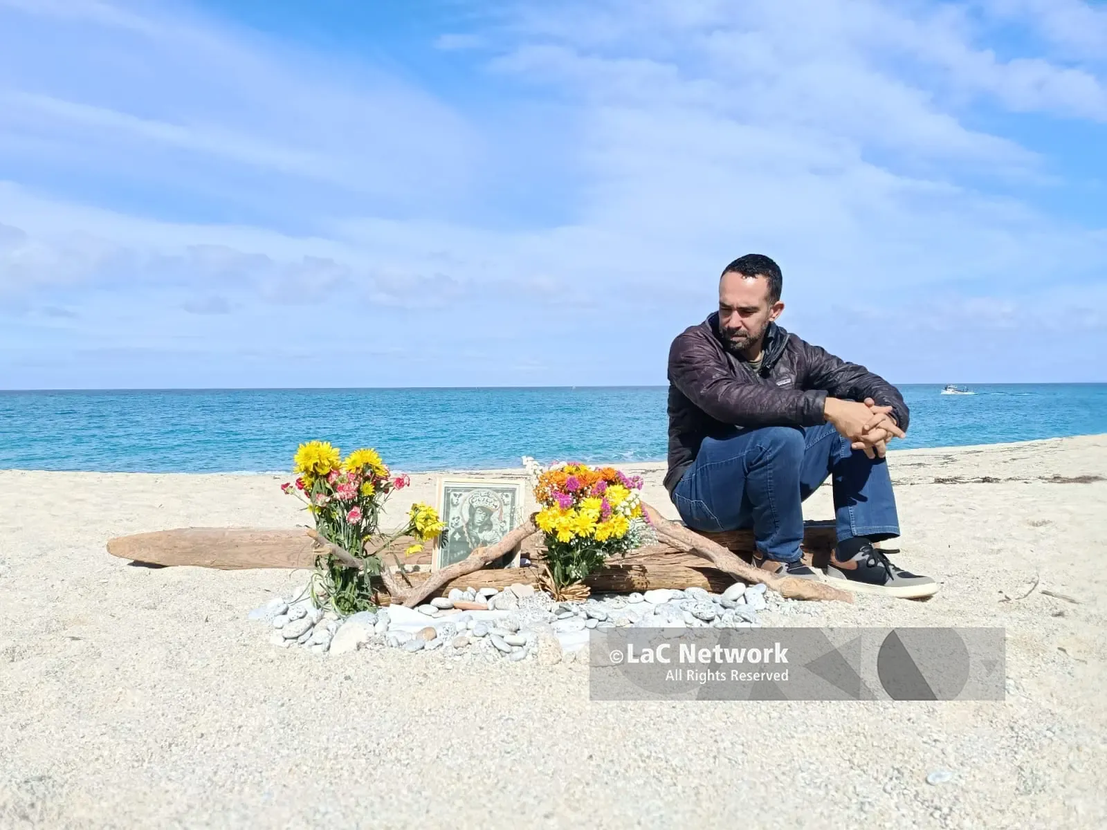 Fiori e silenzio sulla spiaggia di Tropea nel punto in cui il mare ha restituito il corpo di un migrante